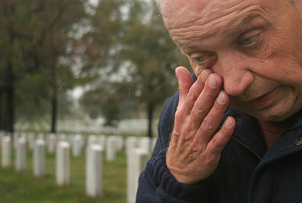 FIRST PLACE: Evan Falk, Ithaca College (Michael Serino, adviser) — Dennis Sendziol, of Naperville, Illinois, visits the gravesite of Sergeant Robert Potock in Arlington National Cemetery on Friday, Oct. 26, 2007. Sendziol owes his life to Potocki after being rescued by him during the Vietnam War.