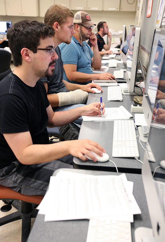 Vinny Vella works on the daily newspaper student produced as part of the Dow Jones News Fund internship workshop at the University of Texas. Photo by Bradley WIlson.