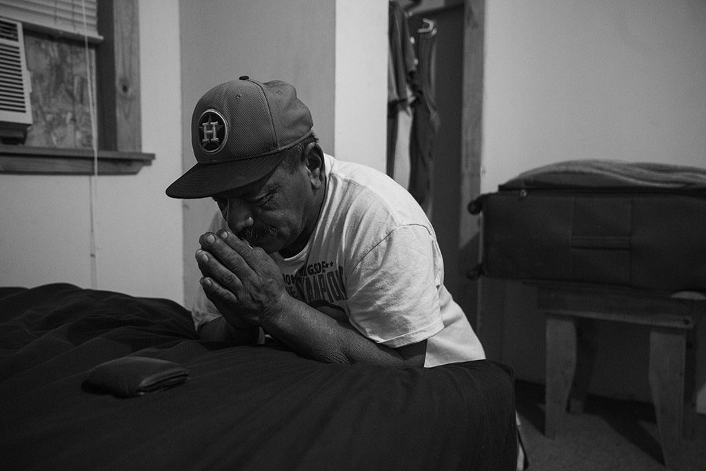 Tino Gaona prays in his bedroom on the morning of his youngest daughter's 24th birthday, which he is missing because he must work in the oil fields, in Cotulla, Texas, U.S. on August 6, 2015. "I miss a lot of birthdays and holidays, but that is how it goes," he said. He prays every morning before going to work in the oil field. Of God, he said, "He's the reason I am still here, so I pray for everybody on my crew."